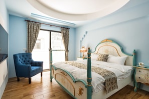 A bedroom with a four-poster bed, a blue armchair, and a wooden floor. - Fun Going B&B (Hualien City)