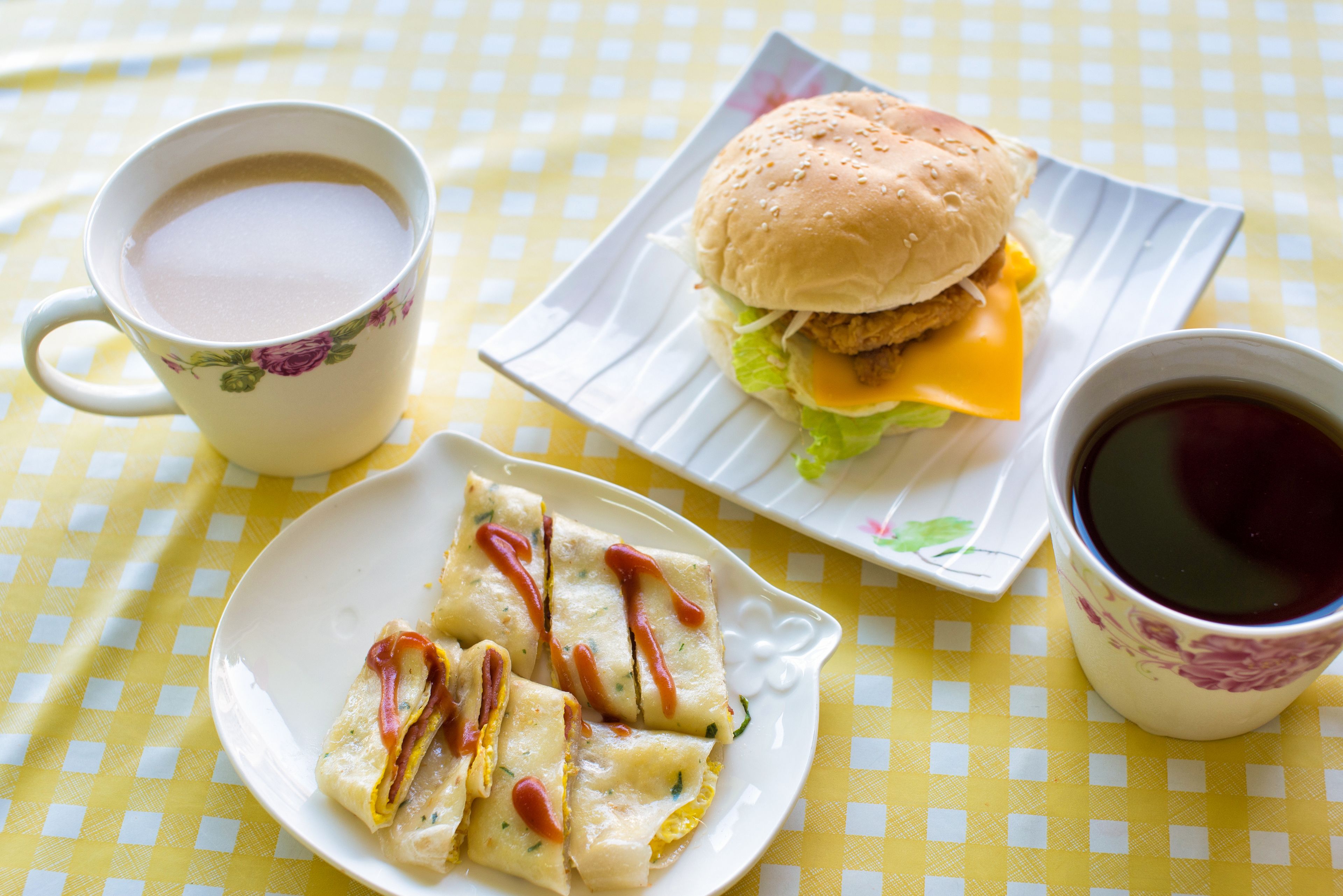 Una mesa con mantel a cuadros, un plato de comida y dos vasos de bebidas.
