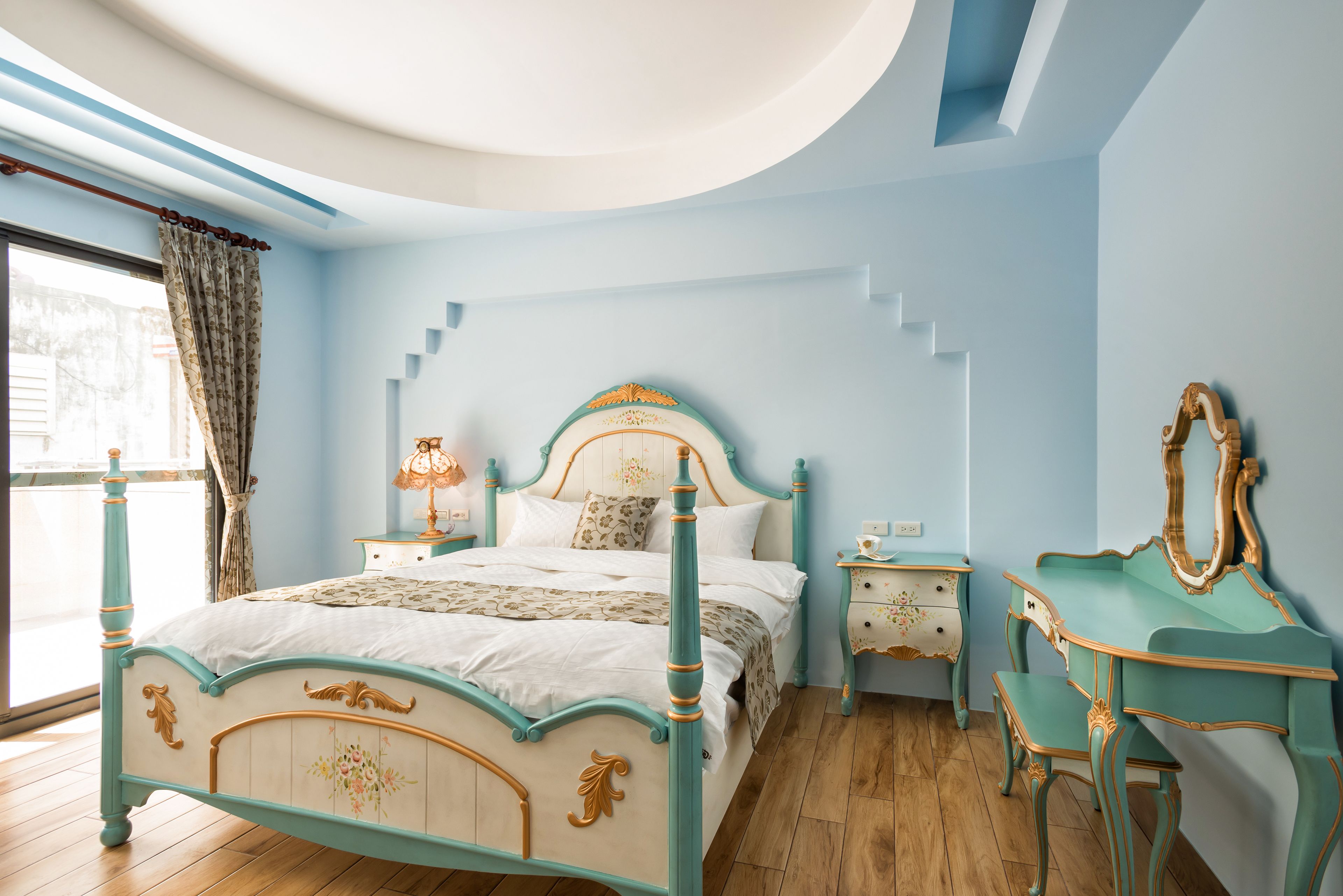 A bedroom with a bed, nightstands, a dresser, and a mirror.