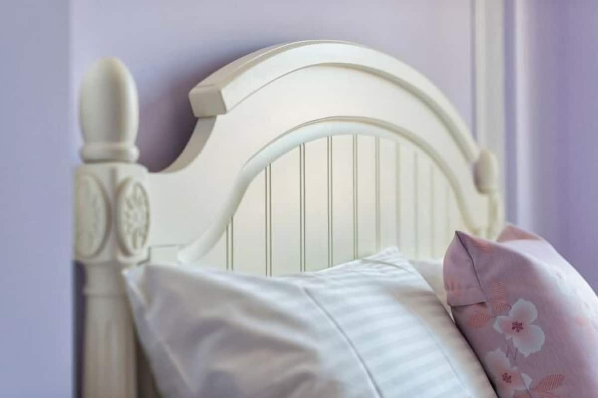 A white headboard with vertical slats and a decorative finial.