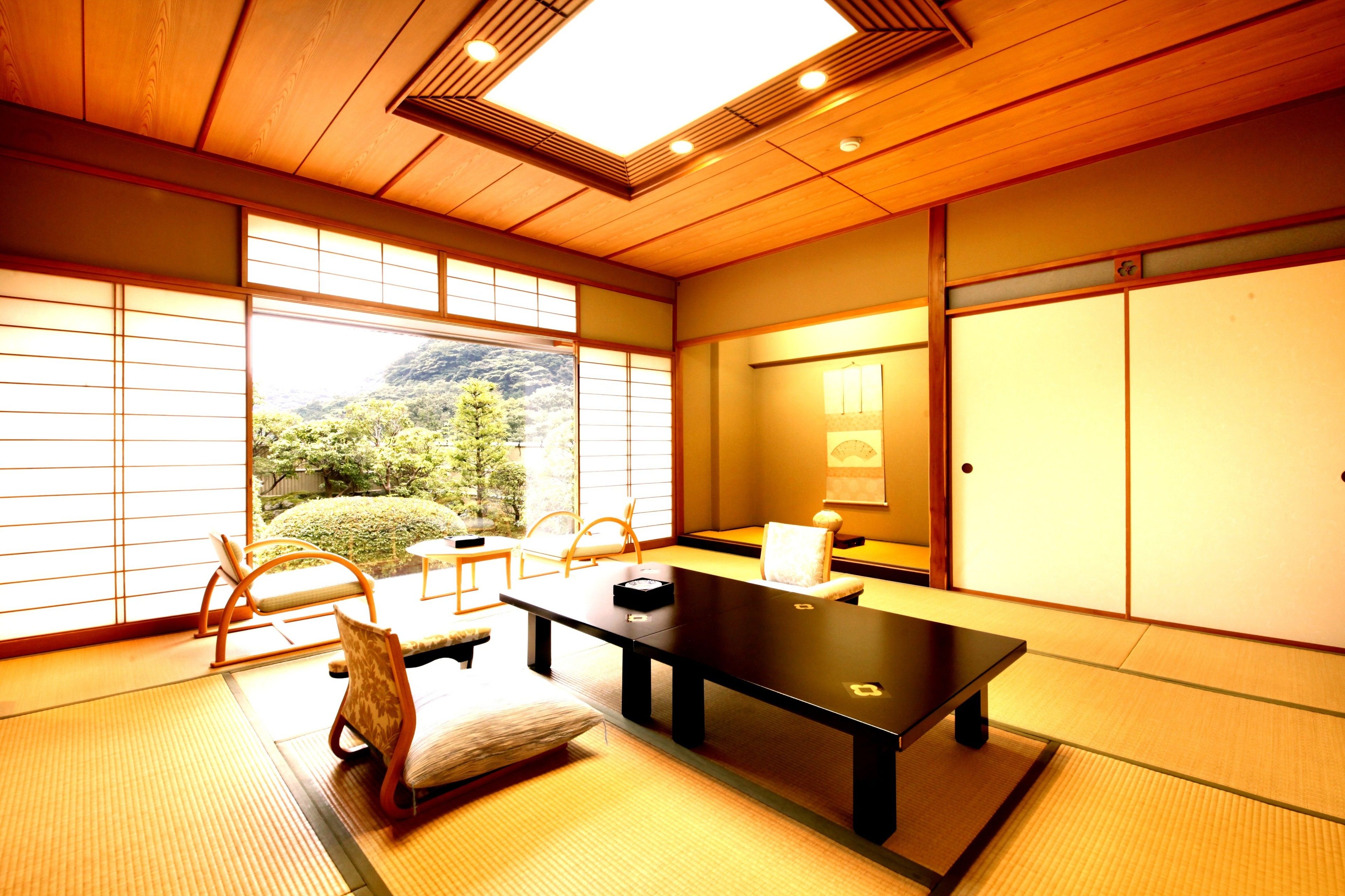 A traditional Japanese room with tatami flooring, a low table, and sliding doors.