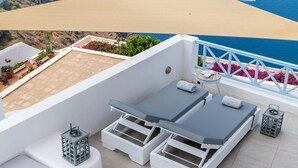 Terraza en la azotea con piscina, sillones de descanso y vistas al mar con cruceros.