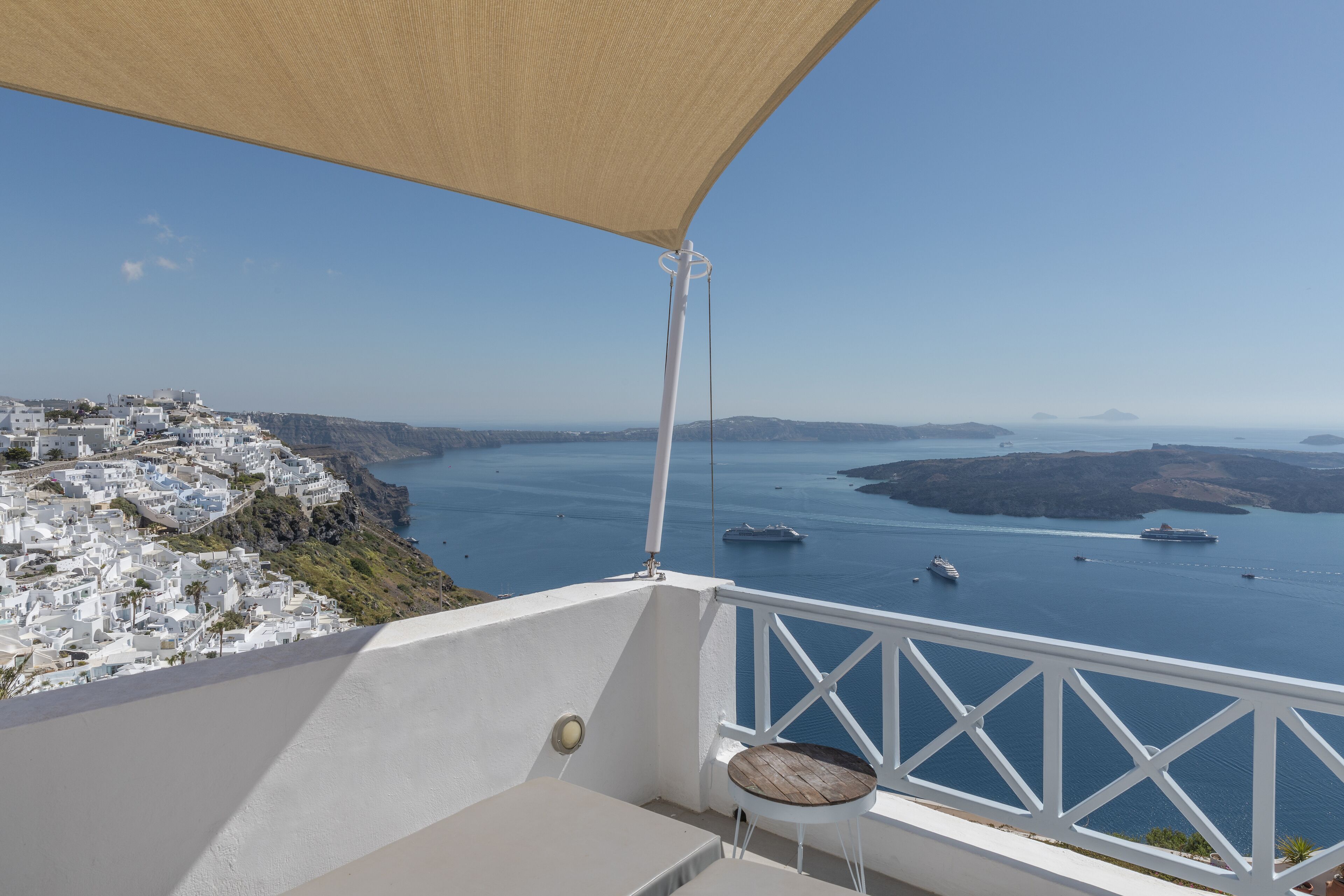 A balcony with a view of a coastal town and the sea.