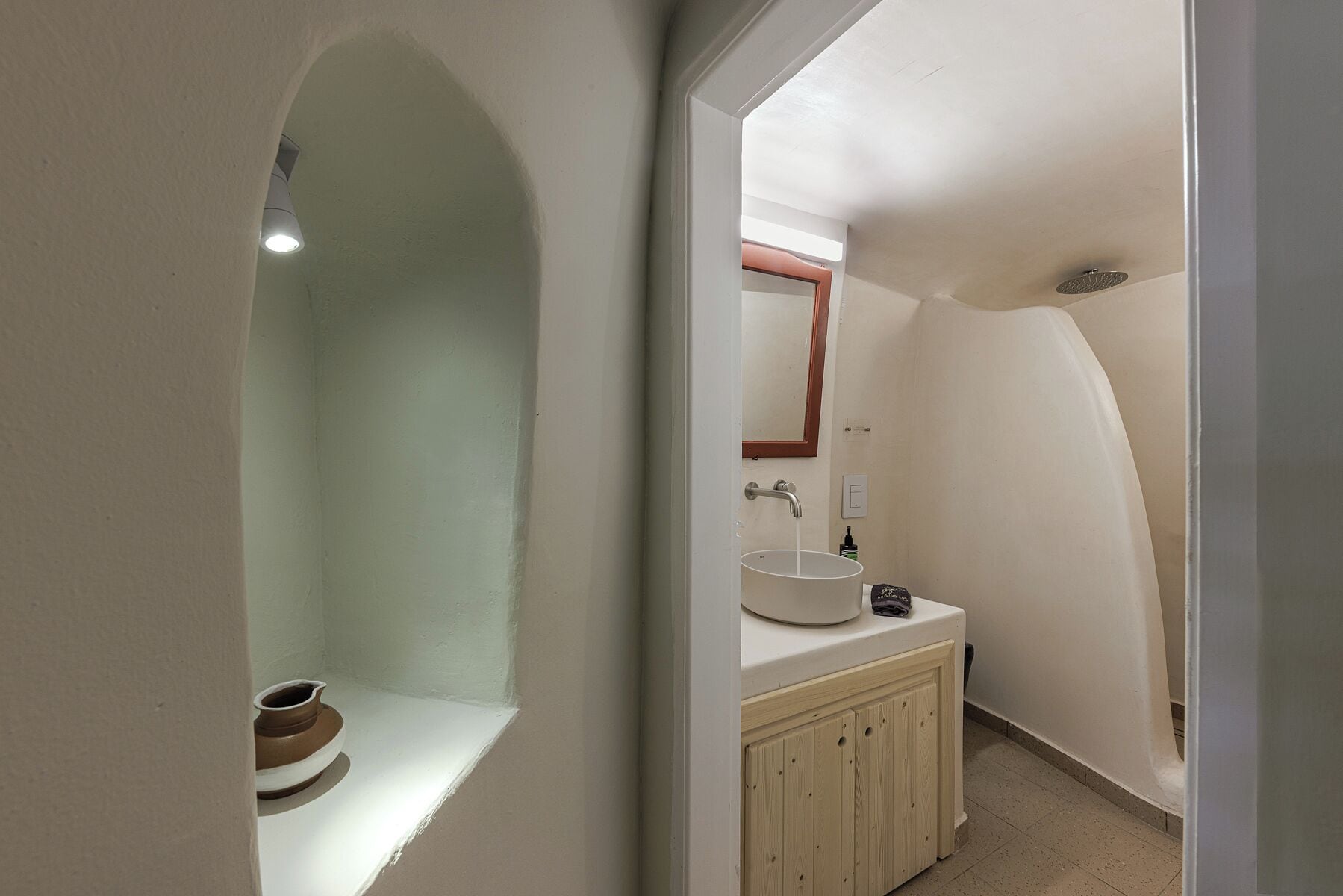 A bathroom with a sink, mirror, and shower.