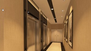 A corridor with double doors, recessed lighting, and framed pictures on the walls. - NU Hotel (Kuala Lumpur)