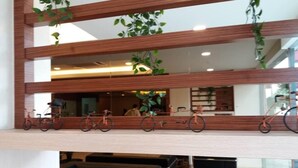 A modern interior with a wooden partition, bicycles, and seating areas. - NU Hotel (Kuala Lumpur)