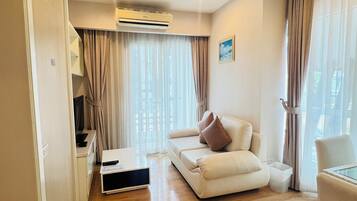Deluxe Twin Room with bathtub | Living area | Flat-screen TV