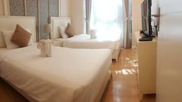 Habitación de hotel con dos camas, un televisor y un armario.