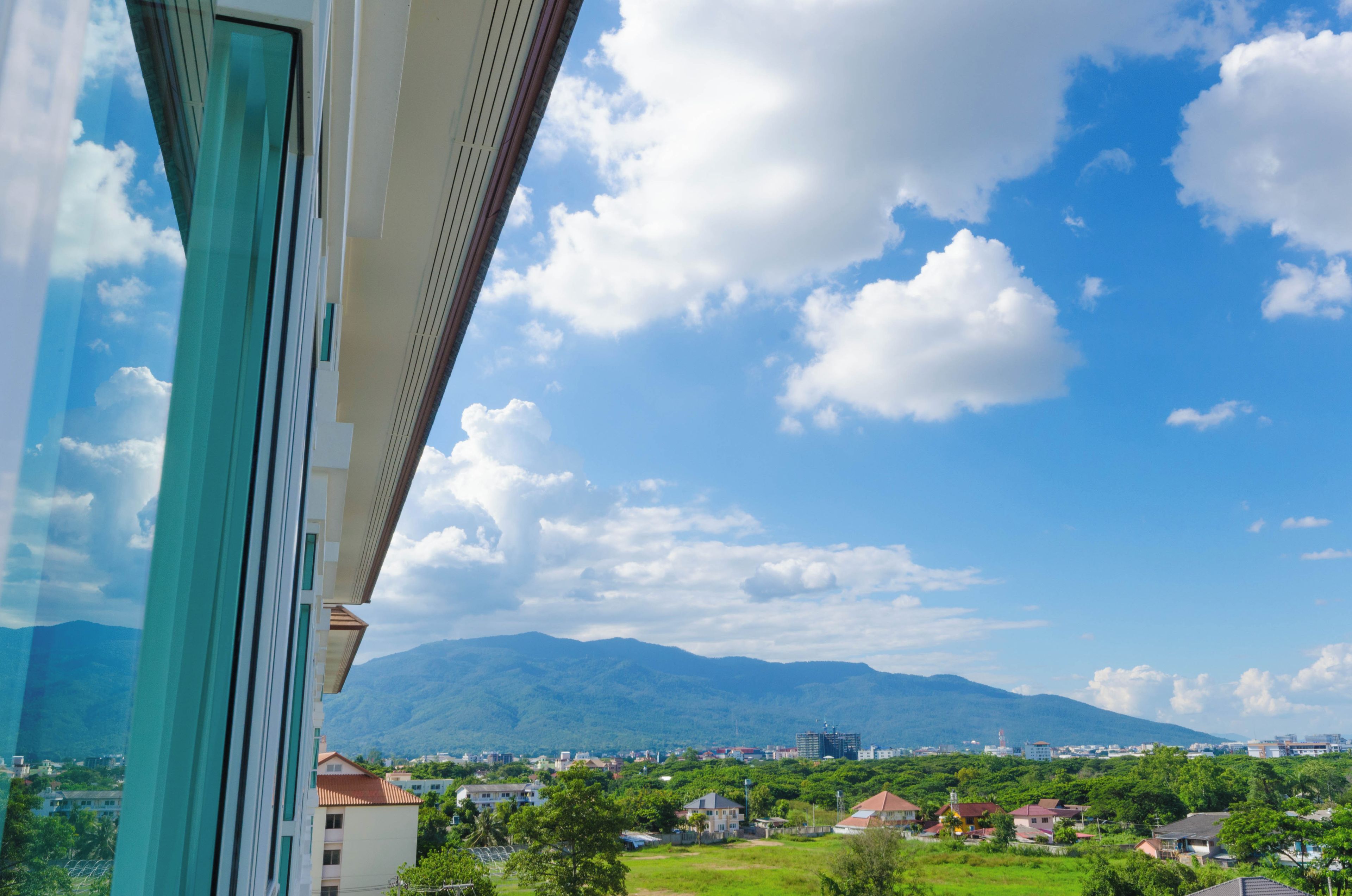 A view from a window overlooking a cityscape with mountains in the distance.