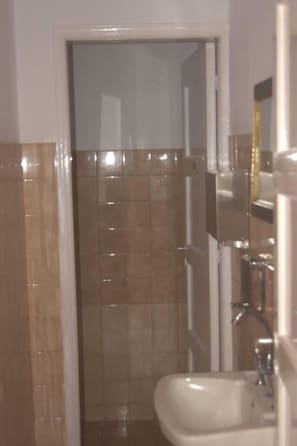 A bathroom with a sink, mirror, and tiled walls. - Medieval Rose Hotel (Rhodes)