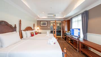 Une chambre d’hôtel avec deux lits, une télévision et un bureau.
