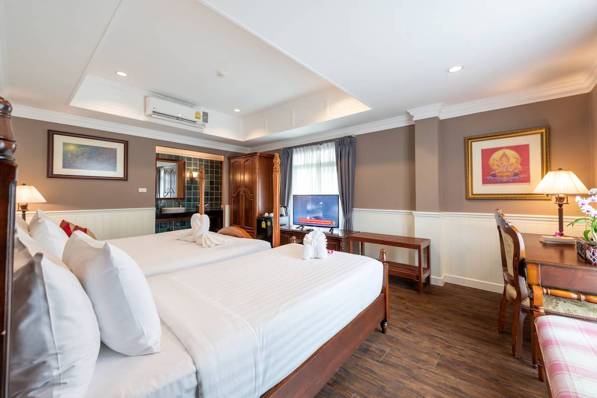 Une chambre d’hôtel avec un grand lit, un bureau, une chaise et un téléviseur.