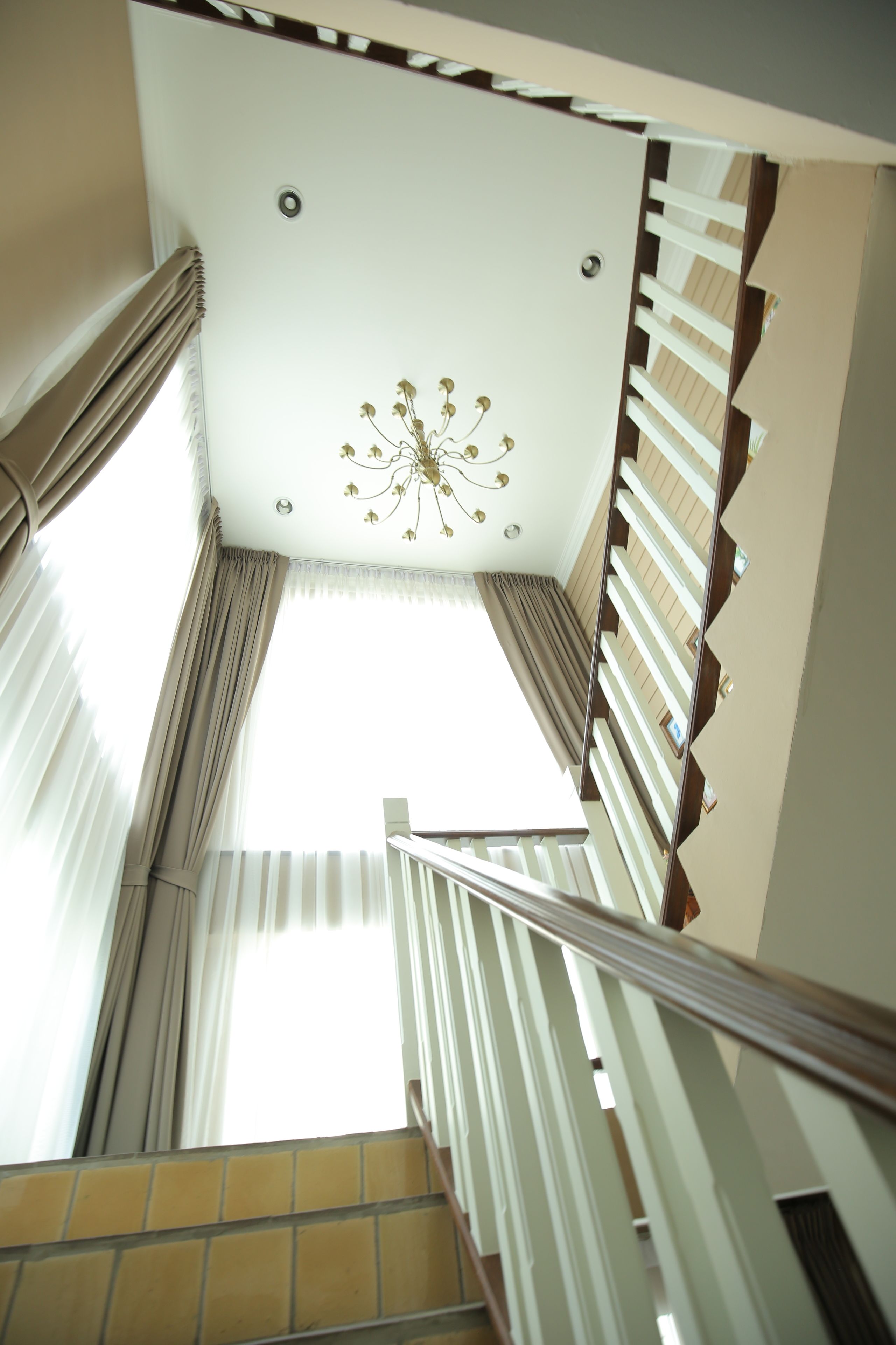 A staircase with a white ceiling and a chandelier.