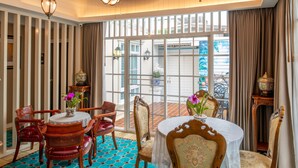 Una stanza con un'ampia finestra, un tavolo da pranzo con sedie e elementi decorativi.