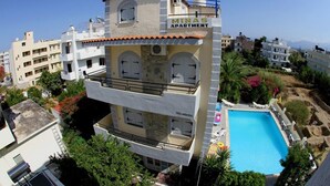 Un palazzo residenziale a più piani con piscina sul tetto e balconi.