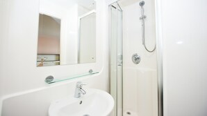 A modern bathroom with a glass shower enclosure, a white sink, and a mirror above the sink. - Citylivein Grove Street Edinburgh (Edinburgh)