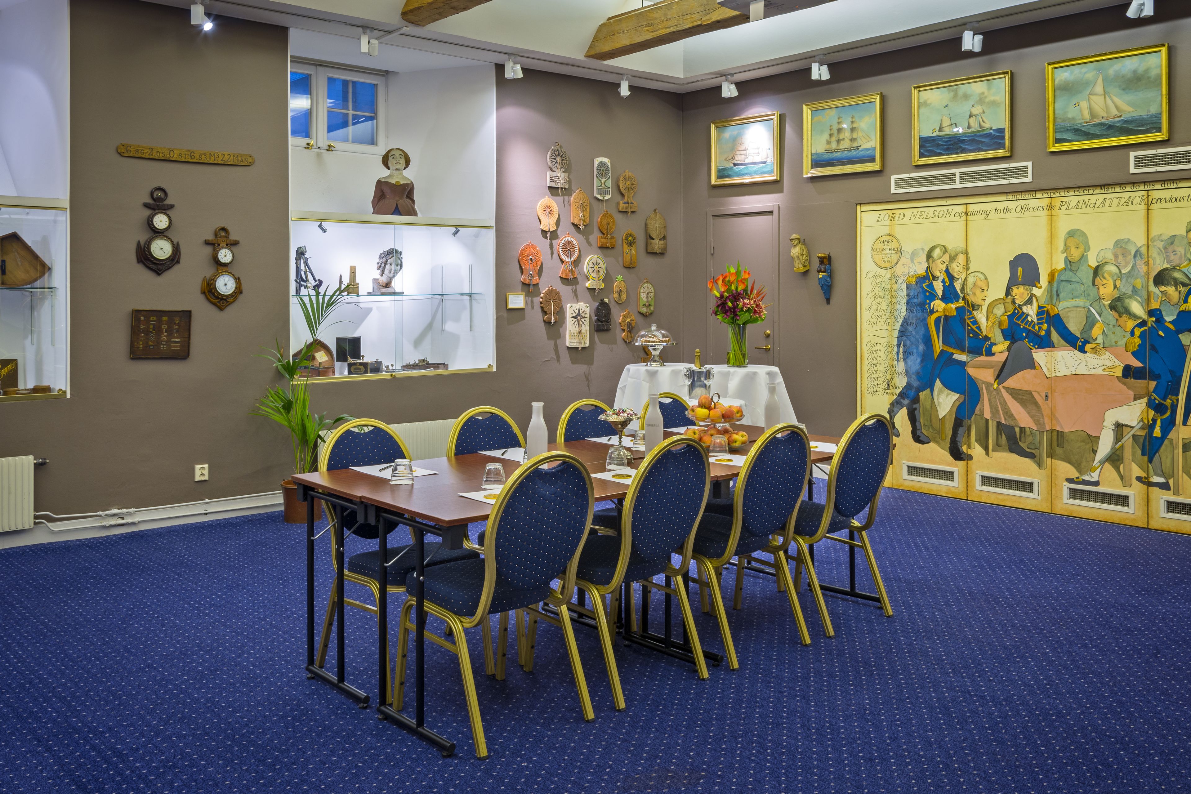 Un coin repas avec une table ronde, des chaises et un tableau accroché au mur.