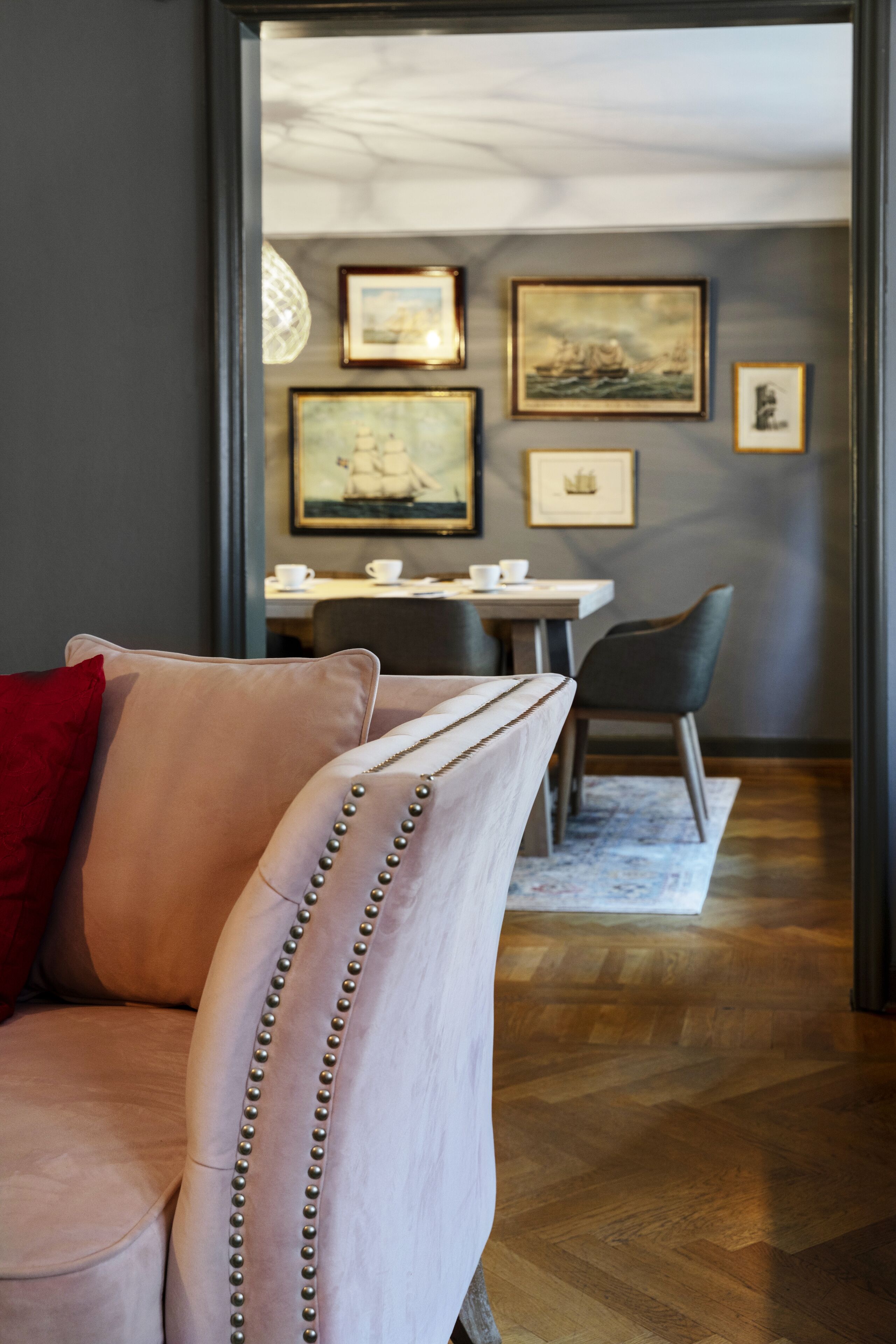 Ein stilvolles Wohnzimmer mit einer bequemen Couch, einem Esstisch mit Stühlen und gerahmten Kunstwerken an den Wänden.