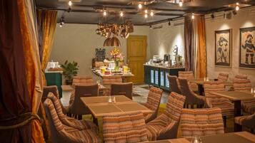 Un restaurant doté de nombreuses tables et chaises, d’un bar et d’un menu écrit à la craie sur un tableau noir.