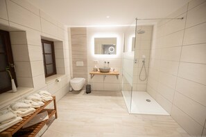 Familiekamer | Badkamer | Een douche, een haardroger, handdoeken