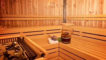 Una sauna con bancos de madera y una zona con bancos de piedra.