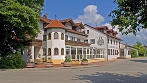 A two-story building with a balcony, a large windowed section, and a sign that reads "Zollverein". - Hotel zum Fischerwirt (Ried)