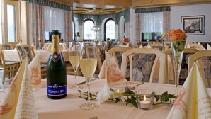 A dining table set for a meal with a bottle of Pommery champagne, glasses, and a rose in a vase. - Hotel zum Fischerwirt (Ried)