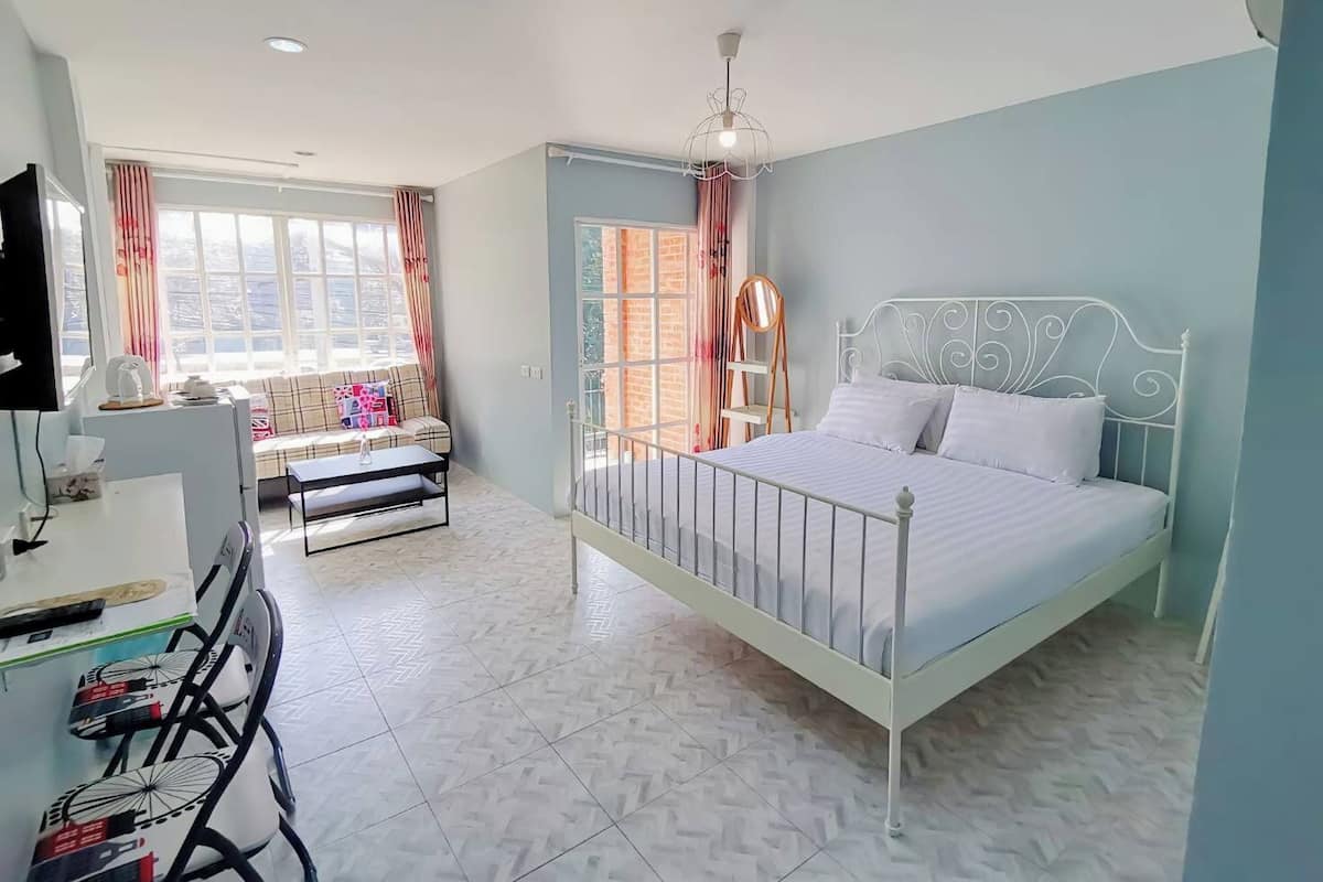 A bedroom with a bed, a desk, and a chair.