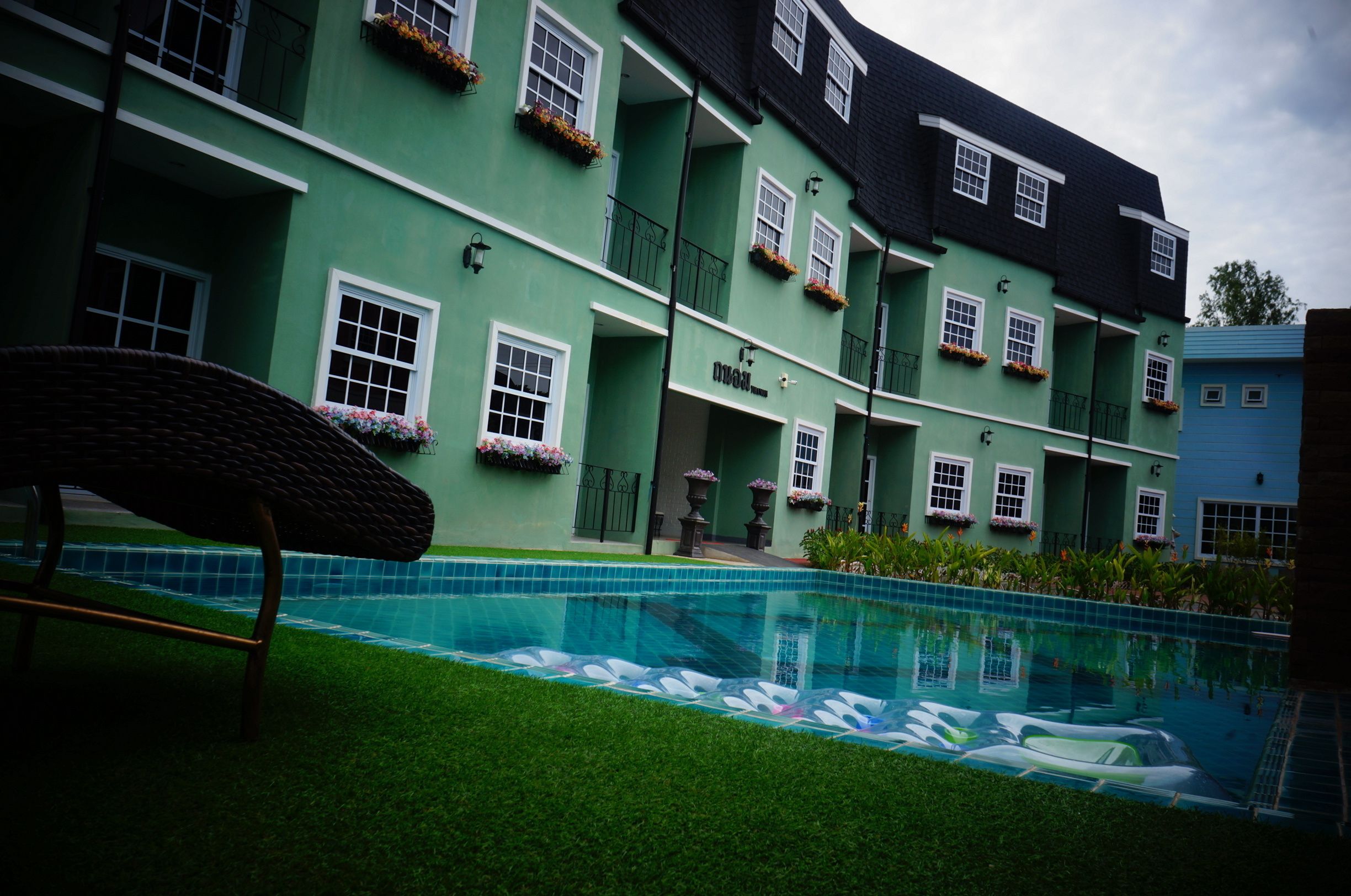 A pool with a clear blue water surface, surrounded by a well-maintained lawn.