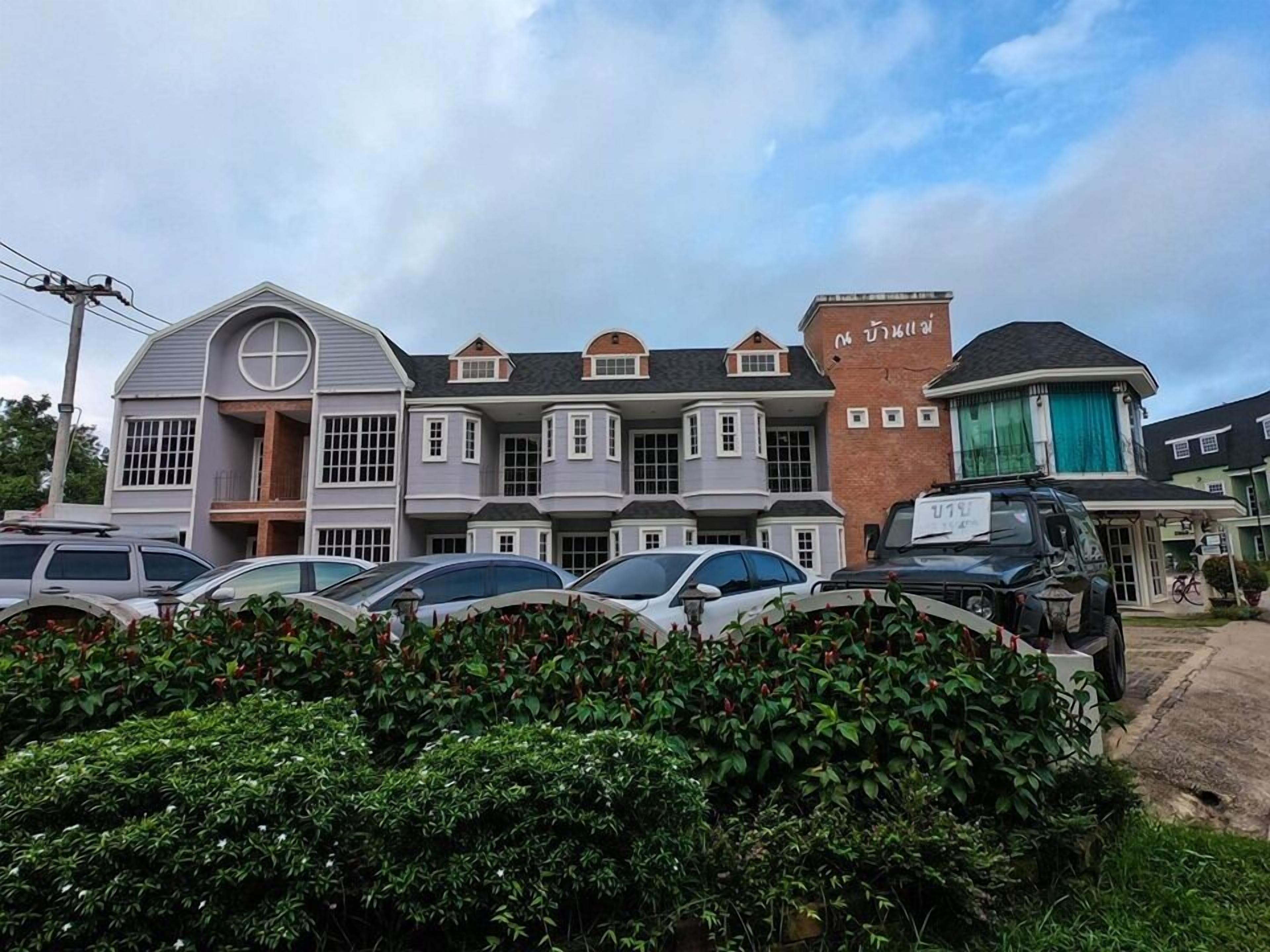 A multi-story building with a mix of architectural styles, including a prominent brick section and a section with a curved roof.