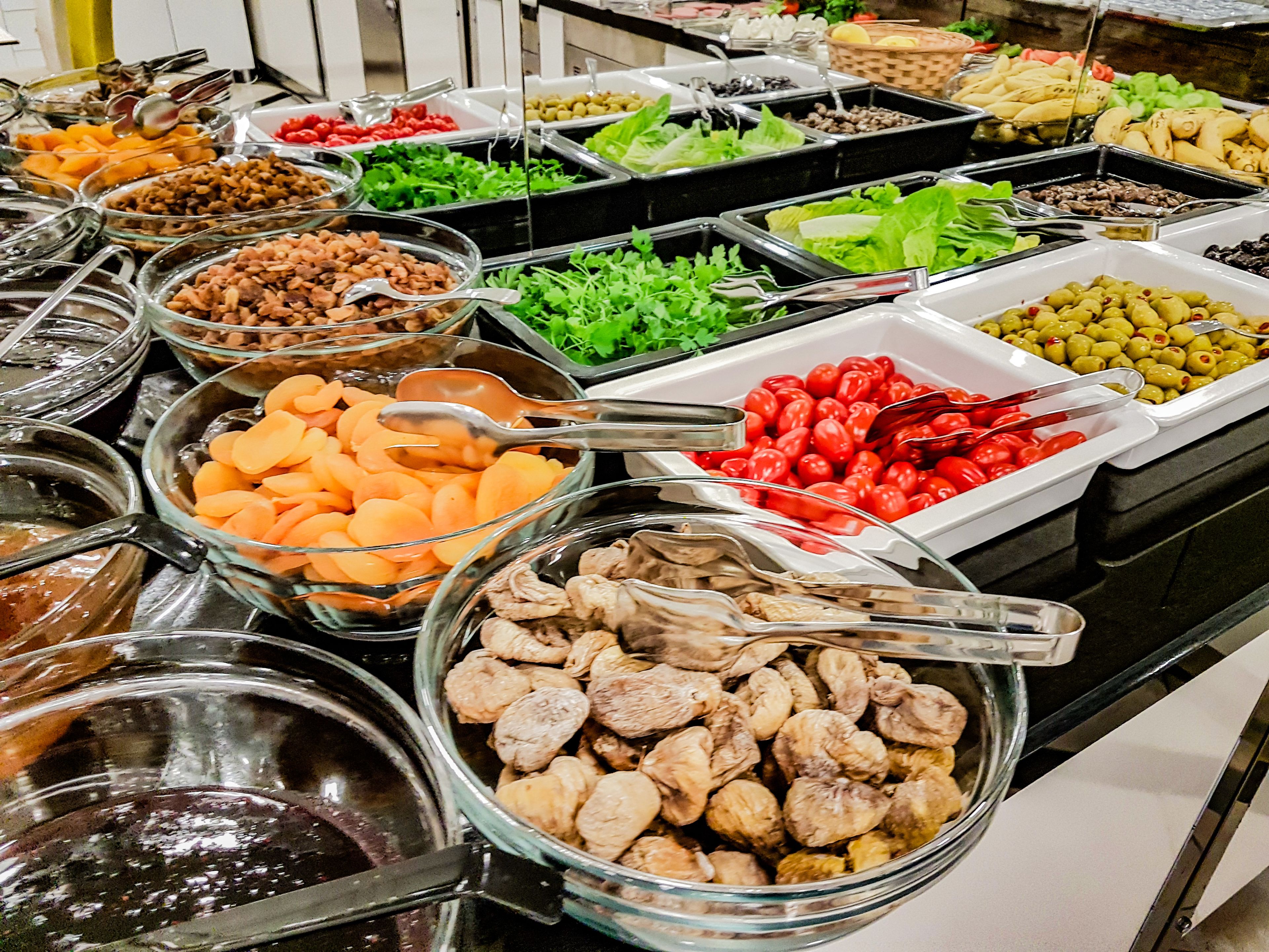 A buffet with various food options including fruits, vegetables, and meats.