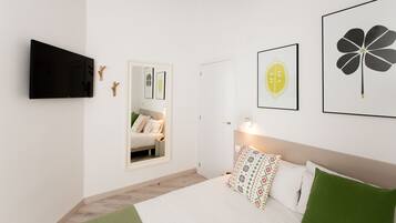 Een moderne slaapkamer met een bed, een televisie en kunstwerken aan de muur.