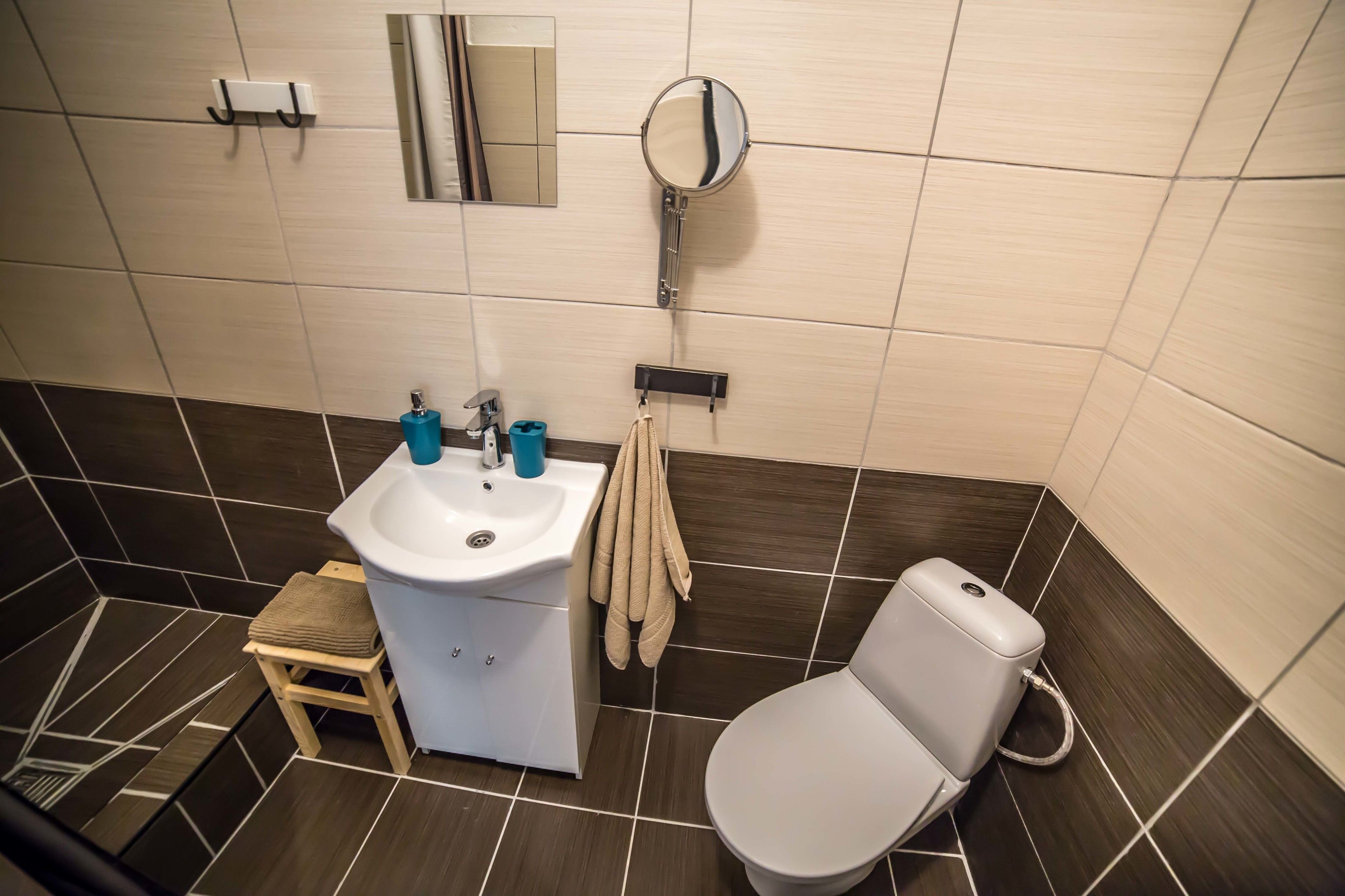 Une salle de bain avec un lavabo blanc, des toilettes et un miroir.