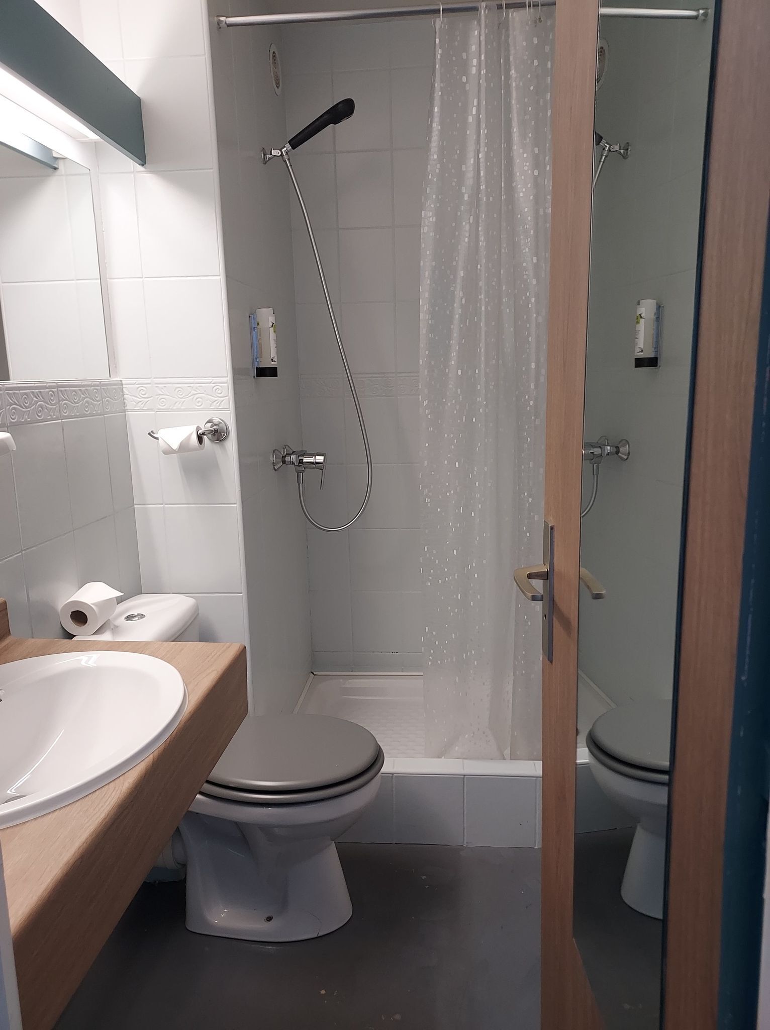 Ein Badezimmer mit Dusche, Toilette und Waschbecken.