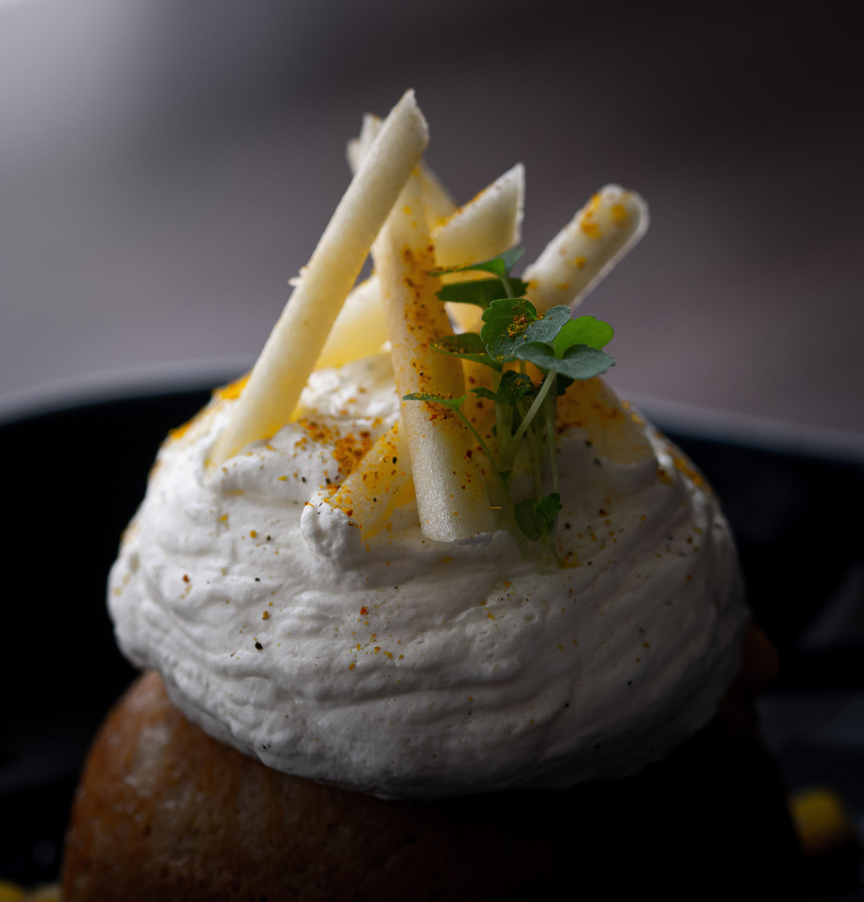 Een dessert met een romige topping, versierd met kruiden en specerijen.
