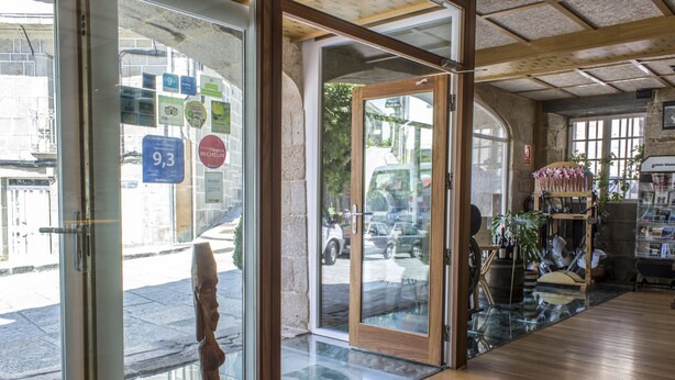 L’entrée d’un hôtel, avec un intérieur en bois, une porte en verre et une vue sur la rue.