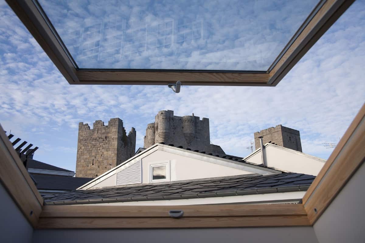 Um claraboia com vista para uma estrutura semelhante a um castelo ao fundo.