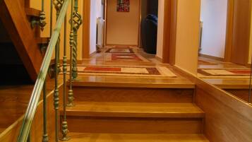 Una escalera de madera con barandilla de metal que lleva a una plataforma.