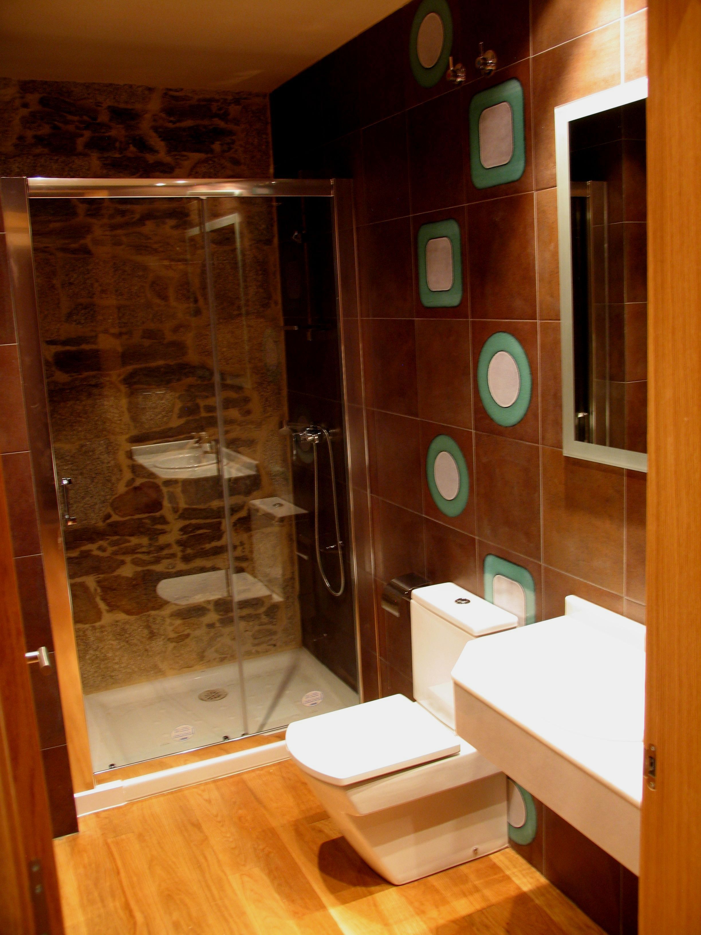 A bathroom with a glass-enclosed shower, a white toilet, and a sink.