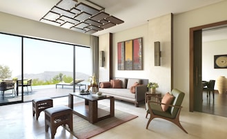Amplia sala de estar con un ventanal, un sofá, una mesa de centro y un sillón.