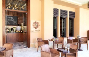 A restaurant interior with wooden furniture, a bar area, and a wall with a decorative emblem.