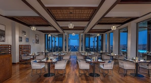 Ein Restaurant mit einer langen Tische, großen Fenstern und Blick auf die Landschaft.