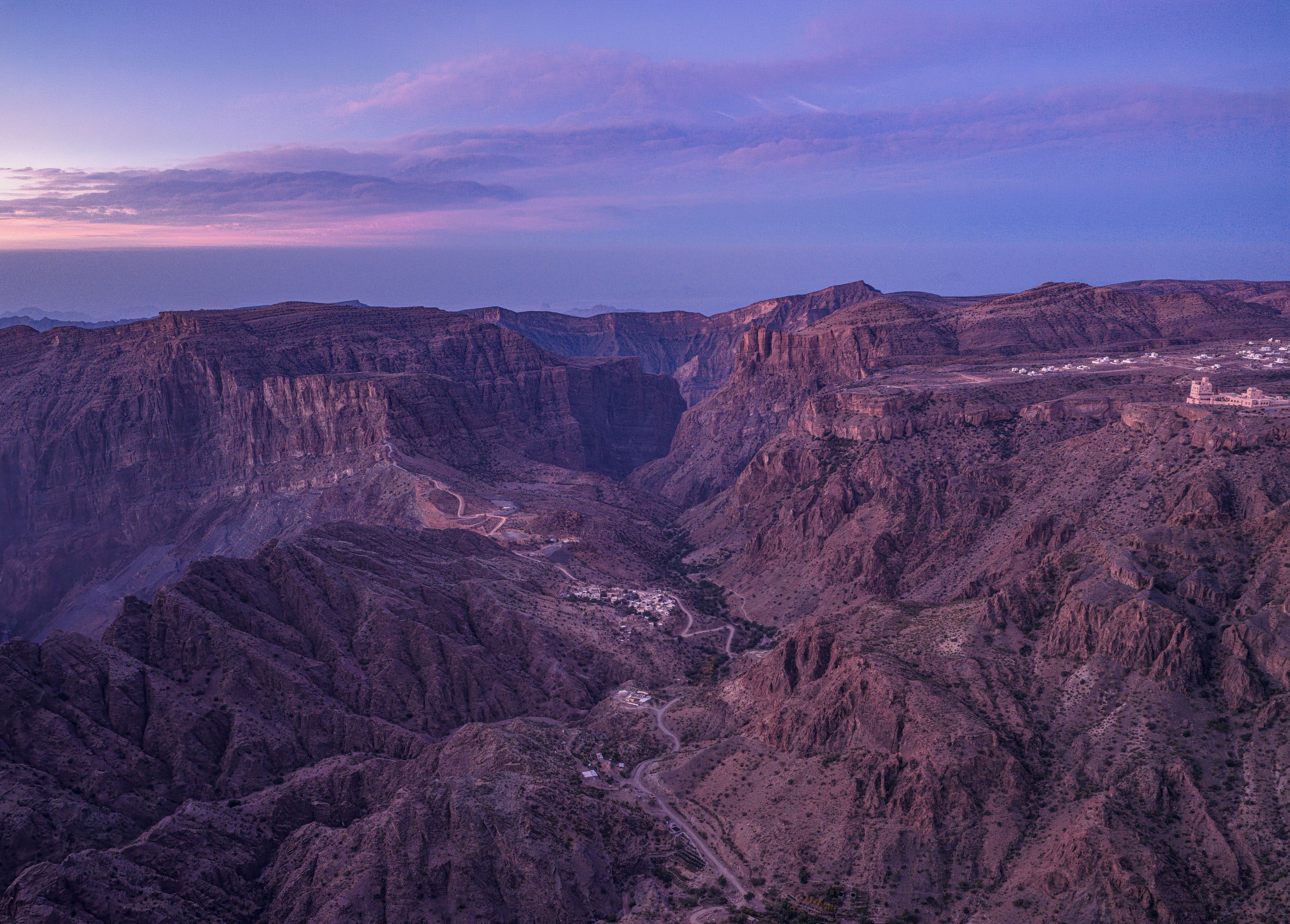 A canyon landscape with a road and buildings.