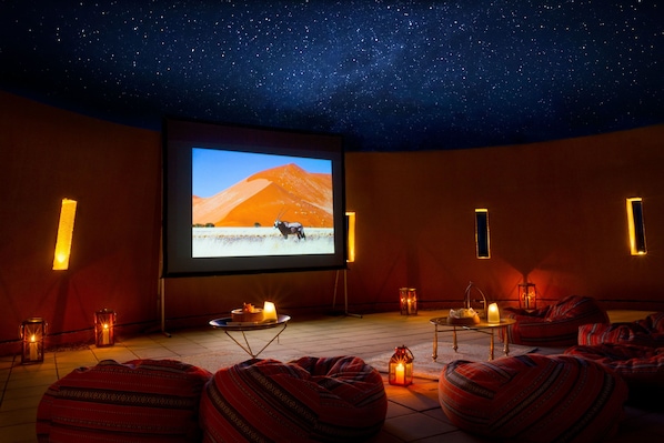 A cozy movie theater with a starry ceiling, a large screen, and comfortable seating. - Anantara Al Jabal Al Akhdar Resort (Nizwa)