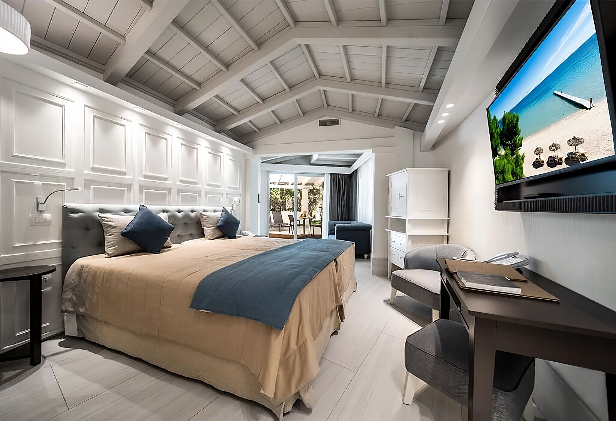 Un dormitorio con cama, escritorio, silla y televisor.