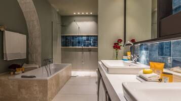 Un baño moderno con bañera, ducha y tocador con espejo.