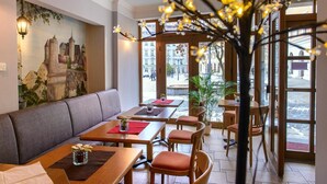 A restaurant with a mural, wooden tables, and chairs. - Zum Handtuch (Bautzen)