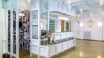 Experience the elegant lobby, featuring a central reception desk, chandelier, and decorative column.