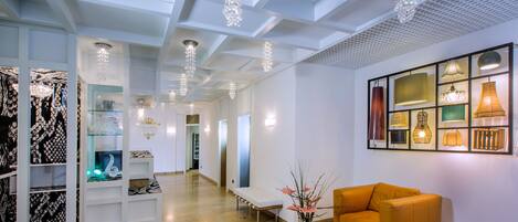 Un moderno vestíbulo de hotel con mostrador de recepción, zona de estar y exhibición de varios objetos.