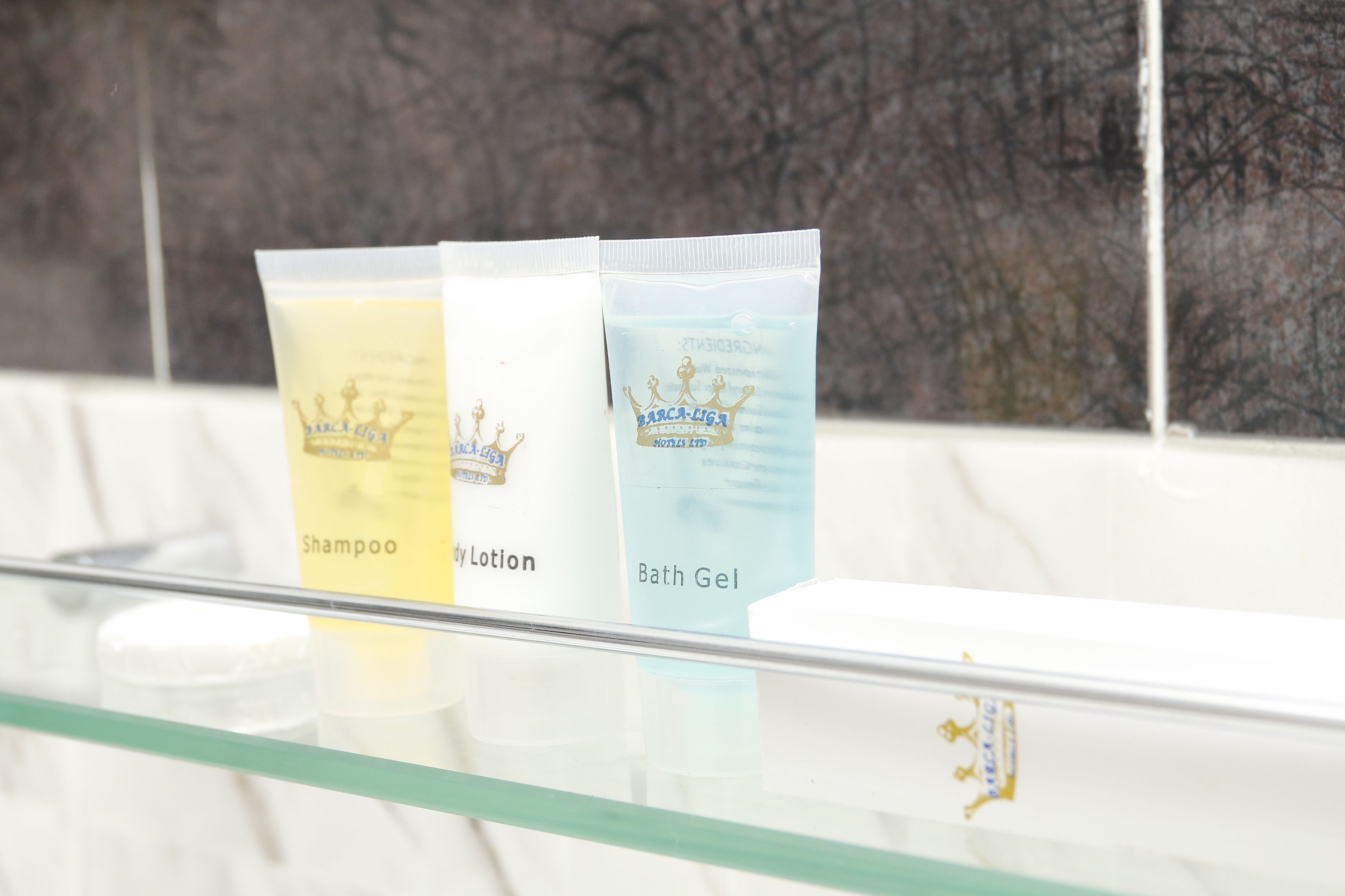 Three toiletry bags on a glass shelf.
